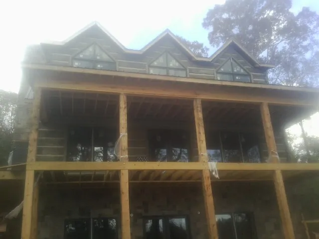 Dormers and porch framing on a large log home under construction — Roof Coating work by our crew in Woodinville