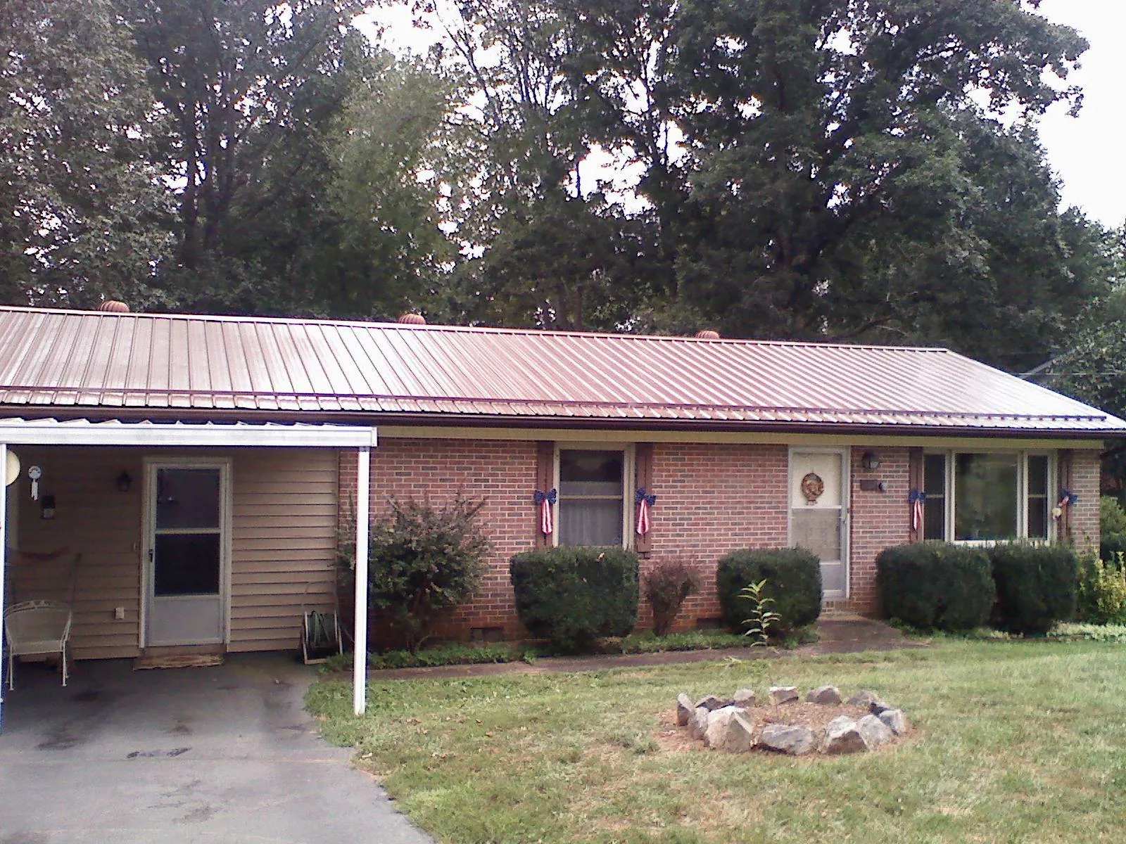 Bronze metal roof and carport on a brick ranch home — Roof Repair work by our crew in Woodinville
